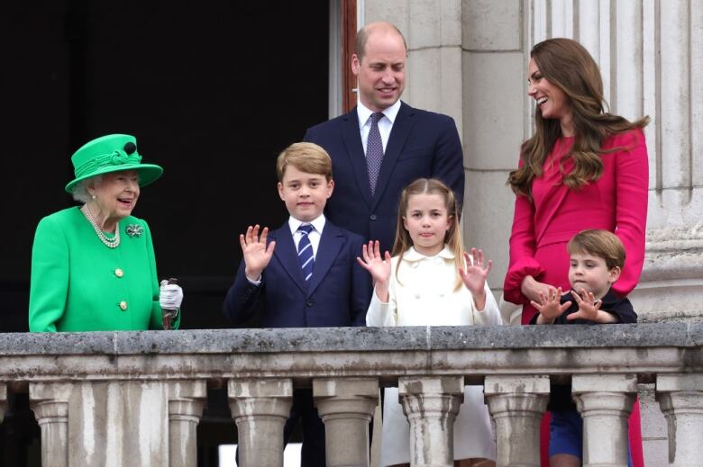 A family waves from a balcony.