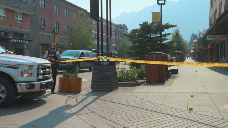 Yellow crime tape surrounds a street in Banff. Crime markers are visible on the road.