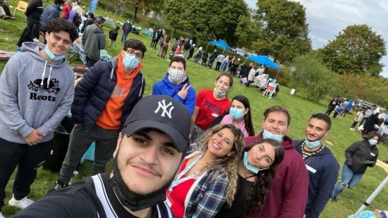 A group of young people pose for a picture at a park.