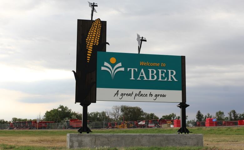 A green sign reads welcome to taber with blue sky in the background