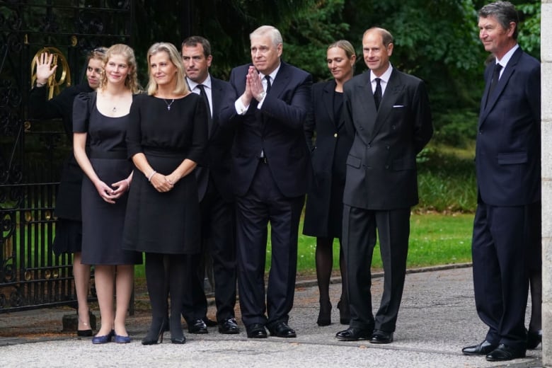 People dressed in black at a funeral.