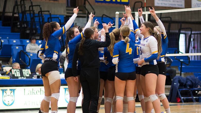 A volleyball team celebrates.