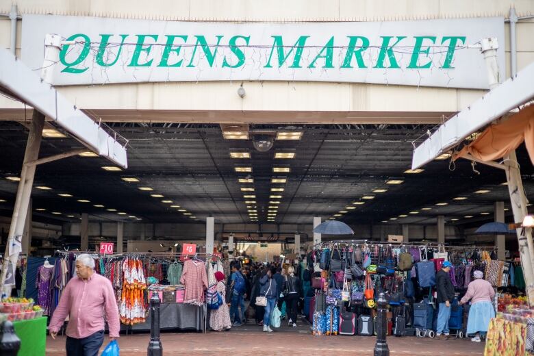 A sign above an open-air market reads Queen's Market