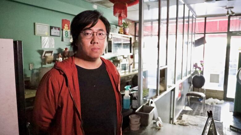 A Chinese man poses for the camera in an office.