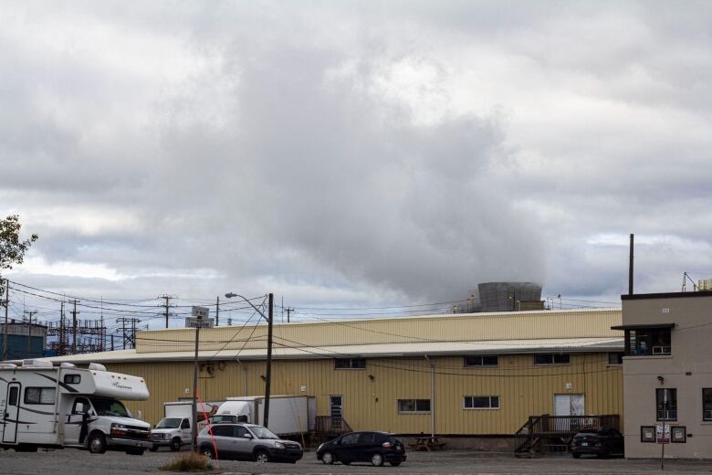 Smoke spews from a low yellow building.