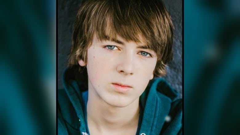 A portrait of a young Ryan Grantham in a green hoodie, against a green backdrop. 