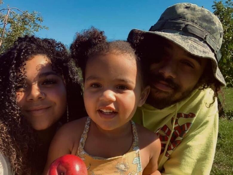 Desormeaux, her daughter and her partner Djavan Blackwell smiling as her mom takes a picture of them in the park. 