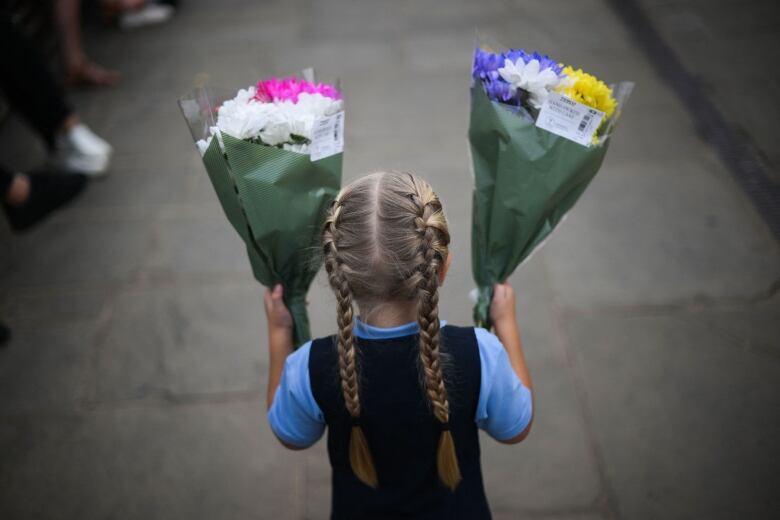 Girl holds flowers.