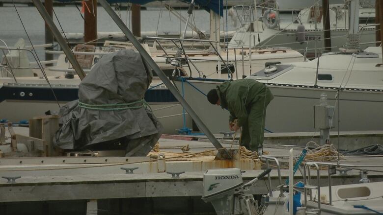 A man works to secure equipment at a harbour in Shediac, N.B. 