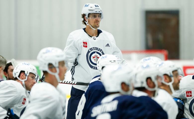 Winnipeg Jets' Mark Scheifele (55) stands amid a group of kneeling teammates as he listens to new head coach Rick Bowness during opening day of their NHL training camp practice in Winnipeg, Thursday, Sept. 22, 2022.