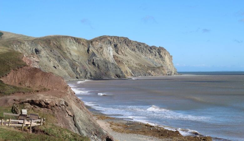 A rocky shoreline with cliffs and a beach.