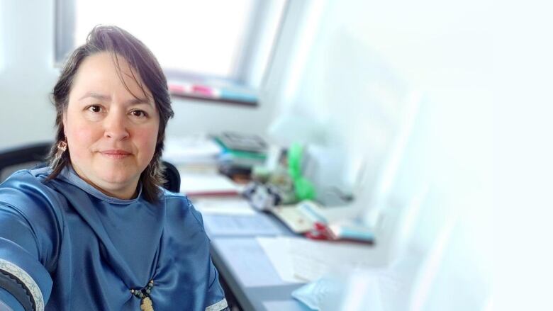 A woman sitting in a bright office.