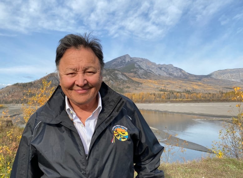 A chief standing in front of mountains.