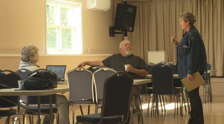 Three people gather for a hot coffee at the Eastern Kings Community Centre, where they've been able to use wifi and electricity while they continue without power.