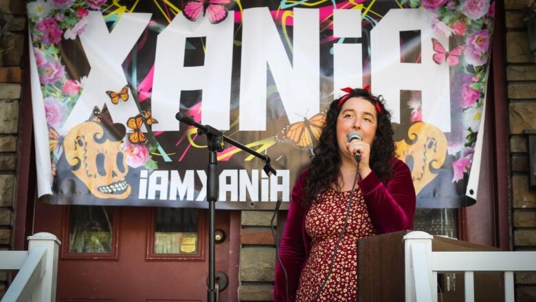 A woman sings into a microphone.