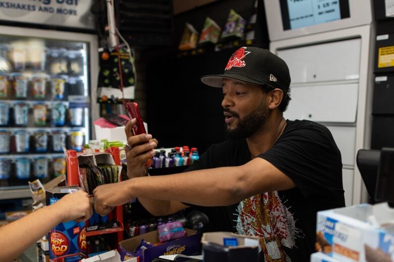 A young man behind a counter in a convenience store.