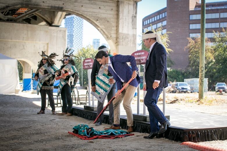 Members of Squamish Nation and Prime Minister Justin Trudeau break ground with shovels at the future Senakw housing development near the Burrard Bridge in Vancouver 