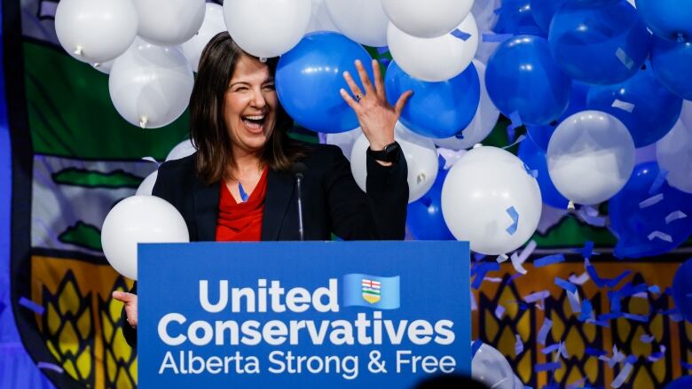 Political woman revels in the midst of balloons.