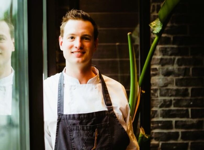 Portrait of a young man wearing an apron.