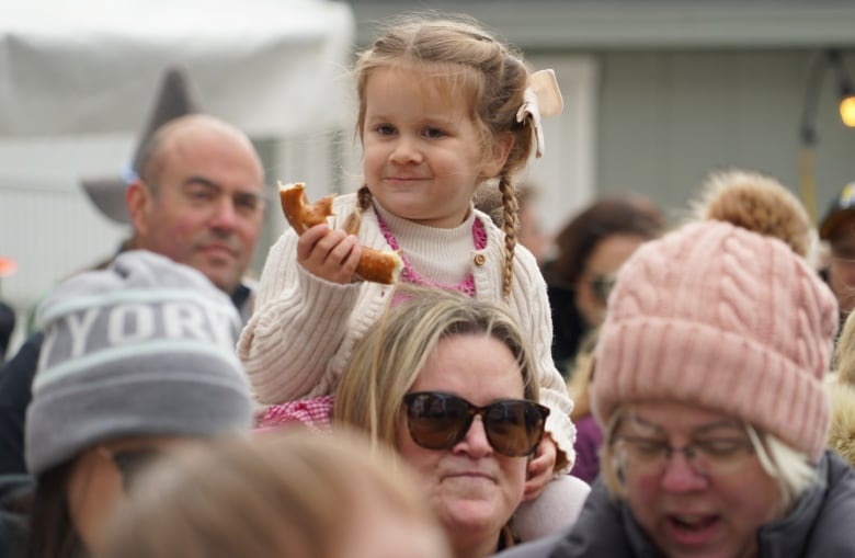 A little girl eats a pretzel.