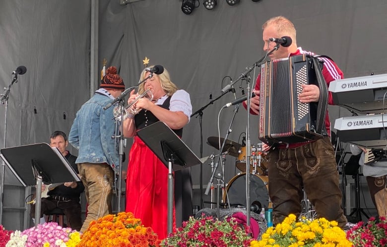 A woman playing the trumpet and a man playing the accordion on a stage.