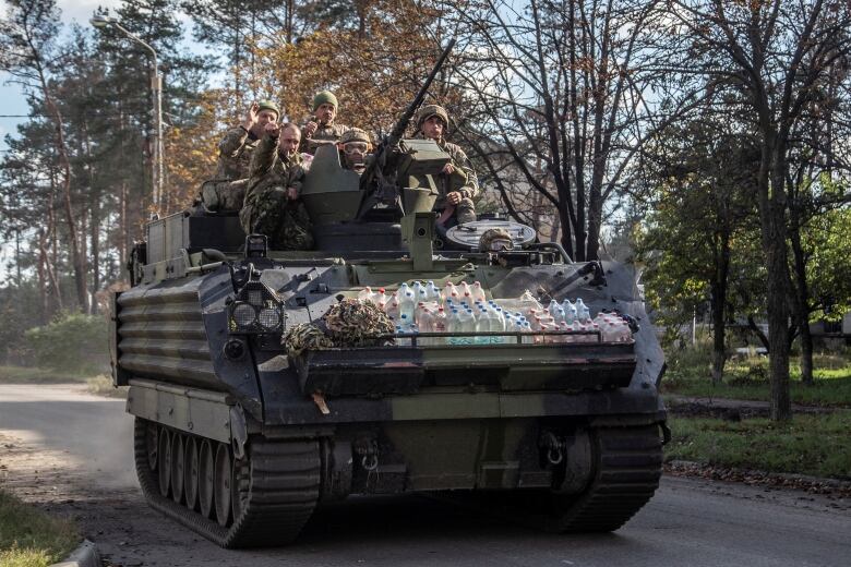 Ukrainian servicemen ride atop of an M113 armoured personnel carrier (APC) in the town of Lyman, recently liberated by the Ukrainian armed forces, amid Russia's attack on Ukraine, Donetsk region, Ukraine October 7, 2022.