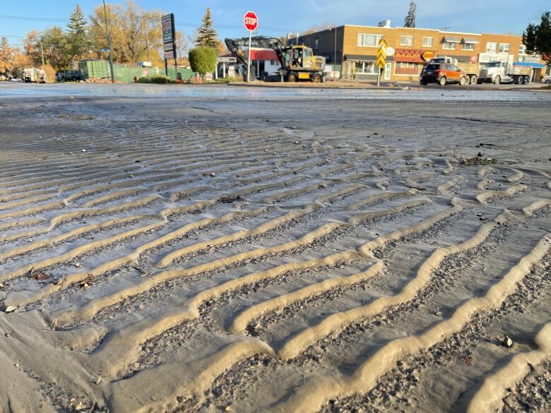 Close up of silt on the ground with buildings in the background.