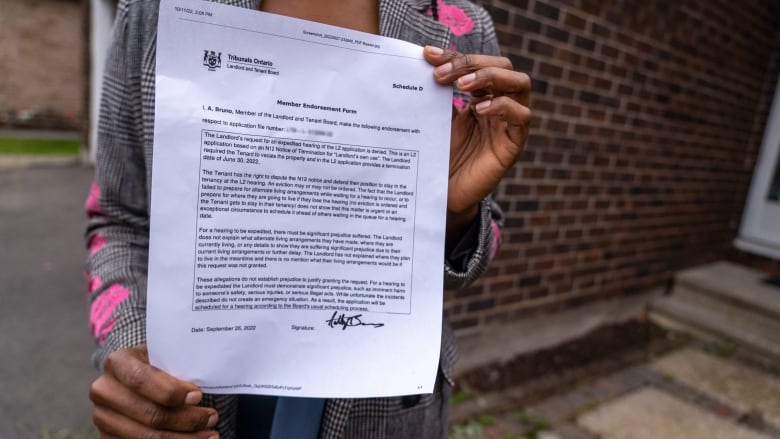 A woman holds up a piece of document.