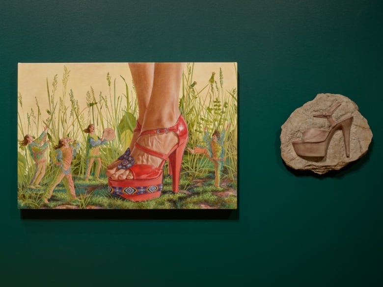 Painting and a sculptural relief of a platform shoe installed on a green wall.