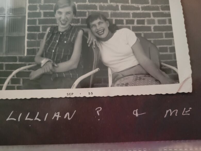 Two teen girls seated in a black and white photo.