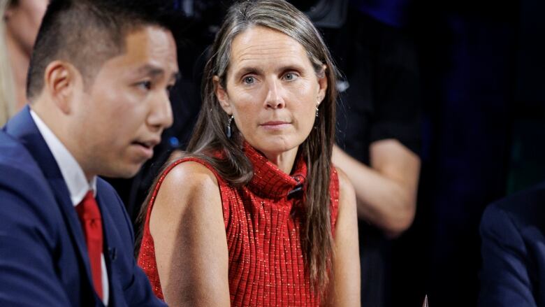 Toronto mayoral candidates Sarah Climenhaga looks on as another candidate makes a remark during the first debate. 