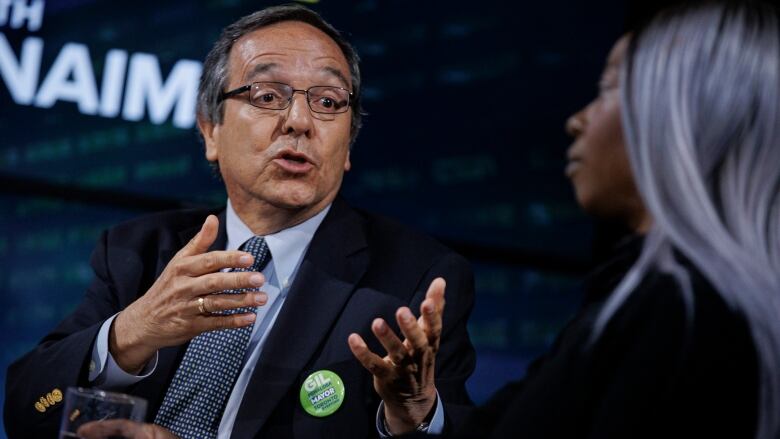 Gil Penalosa, left, takes part in a Toronto mayoral debate alongside Chloe Brown.