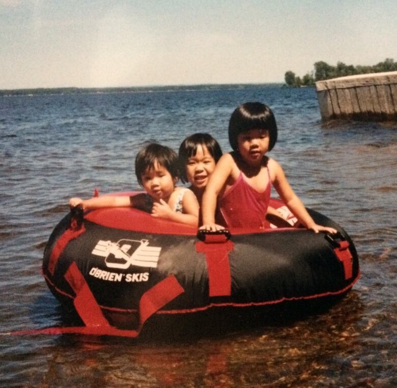 Three girls on a floatie in a lake.