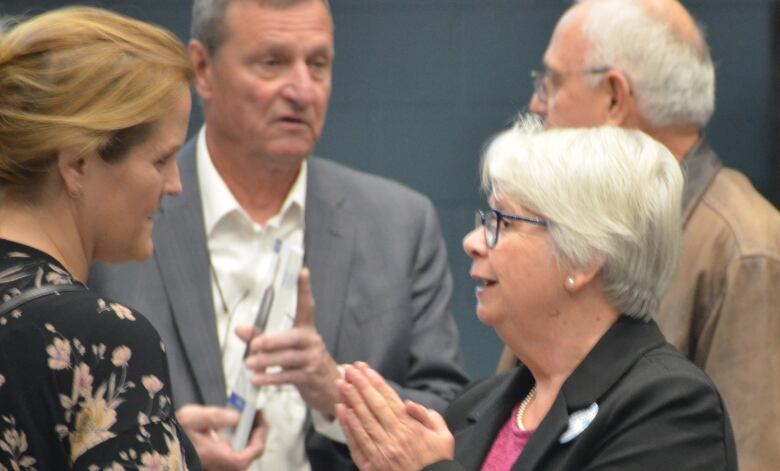 Johanne Brousseau holds her hands together and out in front of her while speaking with Tanya Vrebosch 