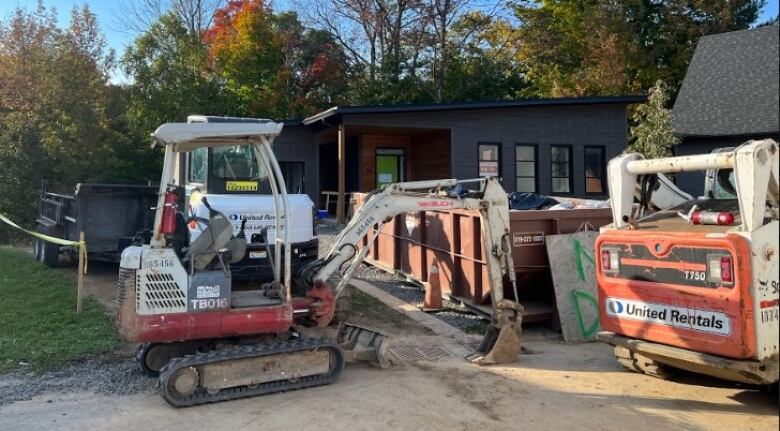 Heavy equipment outside a house.