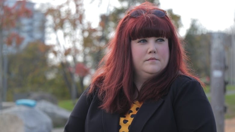 A woman stands in a park.