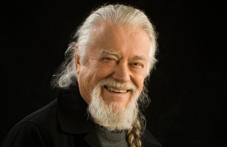 A smiling man poses for a studio photo.