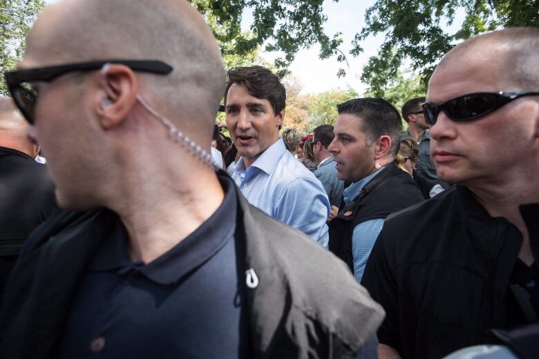 Prime Minister Justin Trudeau, back left, is surrounded by his security detail as he greets people in the crowd during a visit to B.C. Day celebrations in Penticton, B.C., on Monday August 6, 2018.