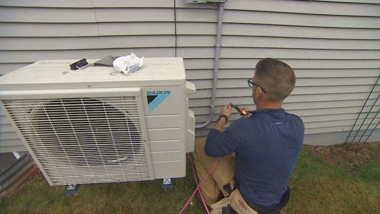 man installs heat pump