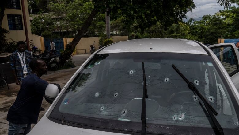 A car window with several bullet holes in it. 