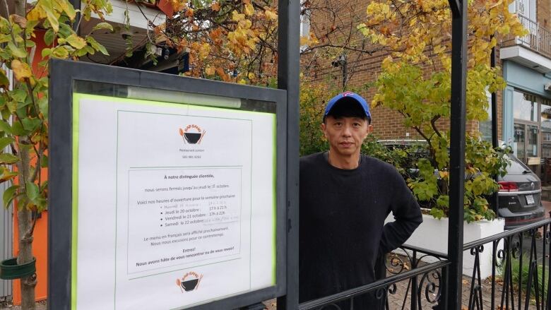 man stands in front of a sign 