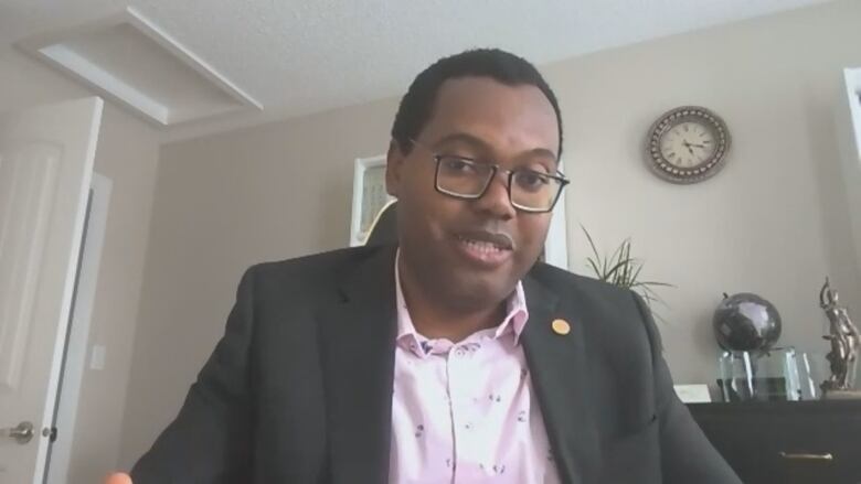  A man wearing glasses looks toward the camera during a video call. 