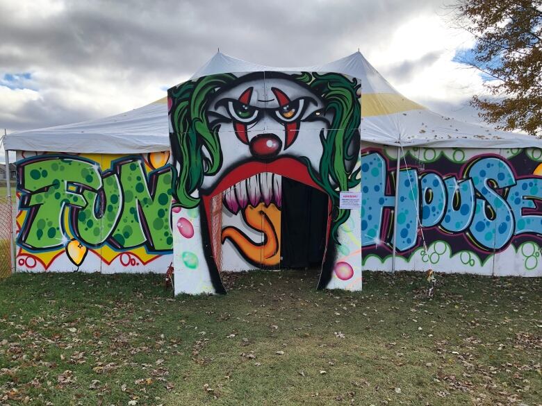 A circus tent with a clown painted on the front and the words 