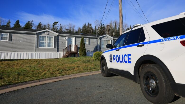 A police SUV is seen on a street in front of a single level home.