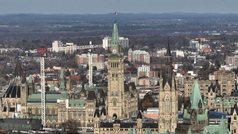 Several Gothic-style towers are seen in an aerial shot taken during daytime of a city skyline.