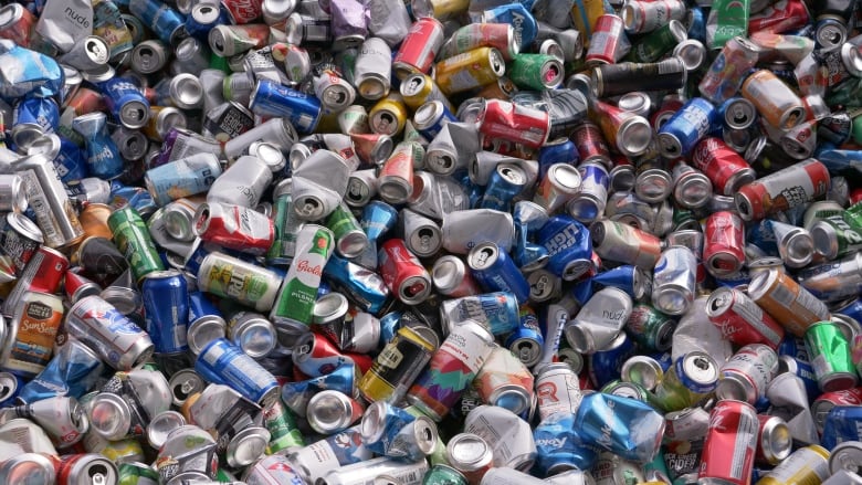 An array of colourful pop cans in a pile.