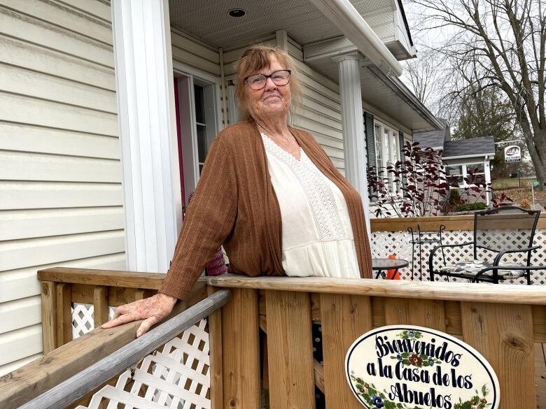 Someone poses for a photo on their porch.