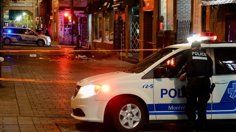 A police officer is standintg next to a police vehicle.