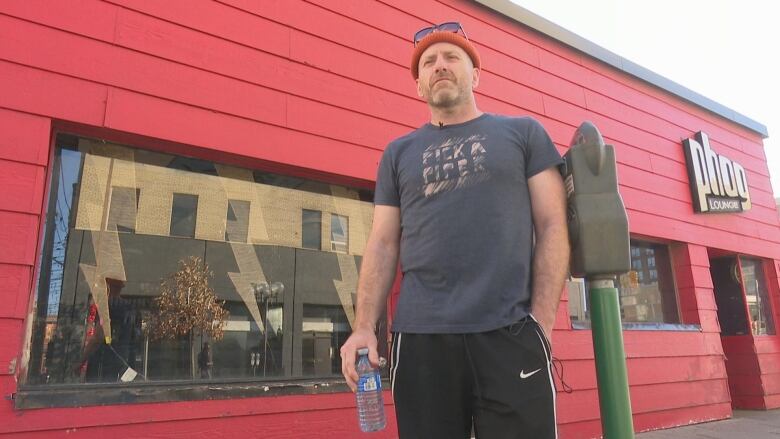 A man stands outside of a building. 