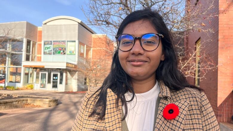 Sweta Daboo facing the camera with UPEI Student Union building behind her.